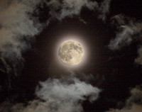 The moon shines through clouds